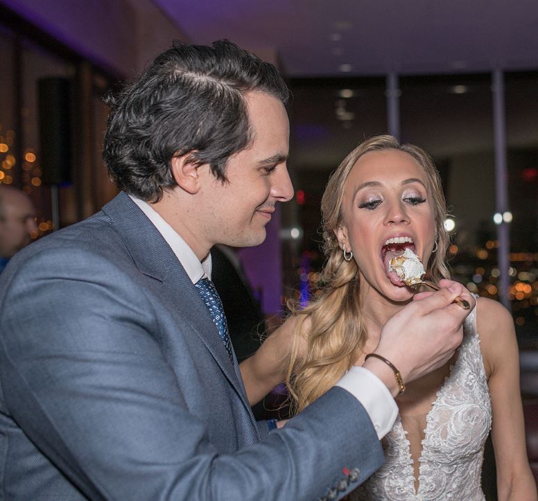 Katherine Timpf and Cameron Friscia eating their wedding cake